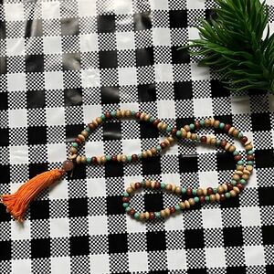 Hand assembled beaded necklace orange tassel